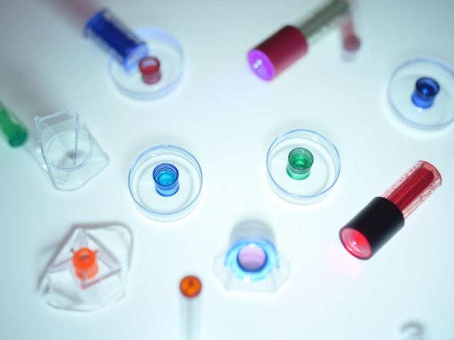 Kit educativo de lentes y prismas para estudiantes, sobre una mesa de laboratorio.